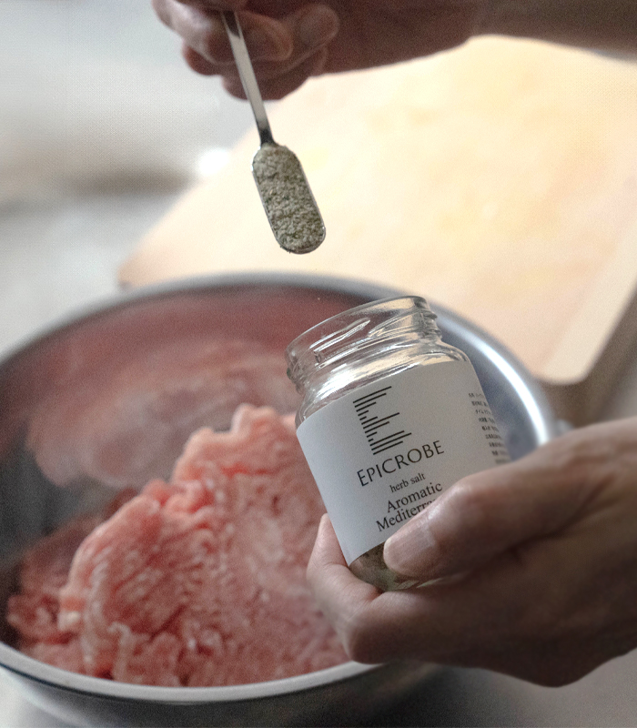 ブレンドハーブソルトを肉にかけている
